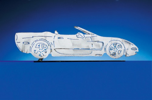 C5 Corvette Convertible. Each CarArtWork Corvette sculpture is 17 inches long and is mounted on a flat metal base. The sculpture is securely attached to the base with a single metal rod affixed to the rear of the piece. The mounting rod is positioned so that its appearance is minimized from the front view of the sculpture. Each piece has a brushed metal finish and is coated with clear lacquer to preserve its luster.